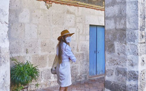 Young woman standing against wall