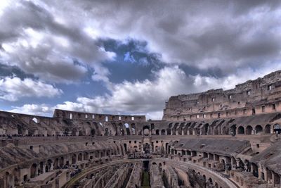 View of coliseum against cloudy sky