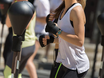 Midsection of woman practicing boxing outdoors