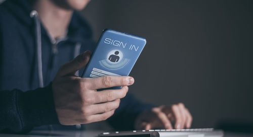 Midsection of man using mobile phone