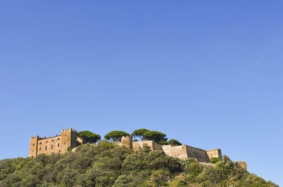 Low angle view of old ruins against clear blue sky