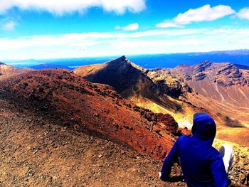 Low section of man on mountain against sky