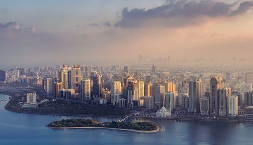 Aerial view of buildings in city against sky