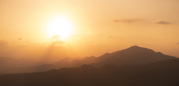 Scenic view of silhouette mountains against sky during sunset