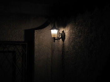 Low angle view of light bulb hanging on wall