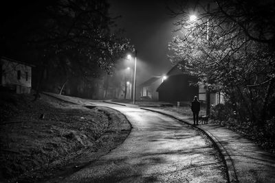 Rear view of woman walking on footpath in city