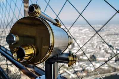 Close-up of coin-operated binoculars against cityscape