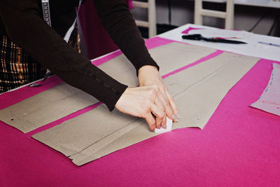 Female fashion designer tailor making sewing patterns at workplace in sewing studio. seamstress