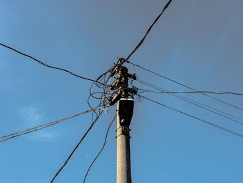 Low angle view of telephone pole against sky