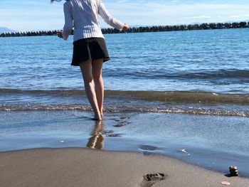 Low section of women standing on beach