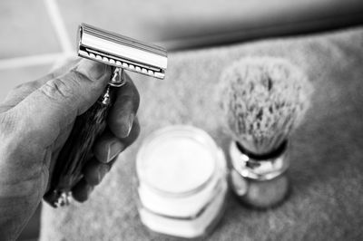 Cropped hand of man holding razor

