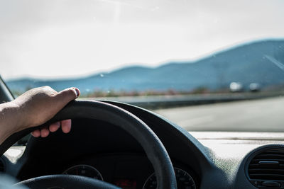 Close-up of hand holding smart phone in car