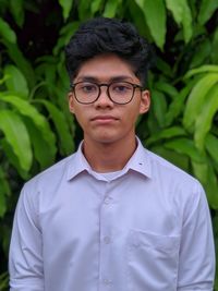 Portrait of teenage boy in eyeglasses standing outdoors