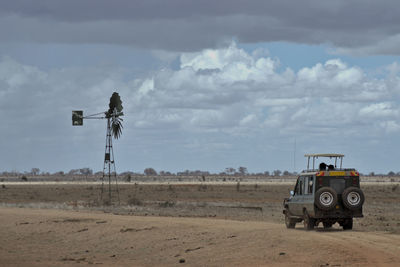 Off road vehicle on field against sky