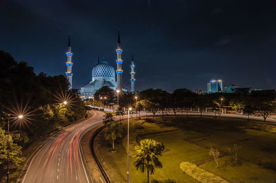 Illuminated sultan salahuddin abdul aziz mosque against sky at night