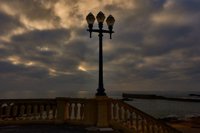 Silhouette statue against sky at sunset