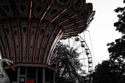 Low angle view of chain swing ride against sky