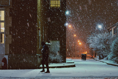 Full length of illuminated street during winter at night