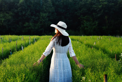 Rear view of woman standing on field