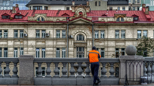 Rear view of man standing against building