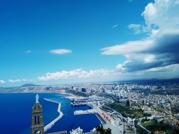 Aerial view of sea and buildings against cloudy sky