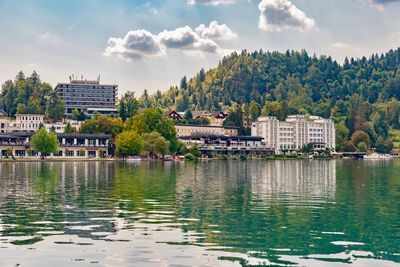 Scenic view of lake and buildings against sky