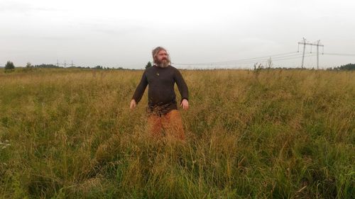 Full length of man standing on field against sky