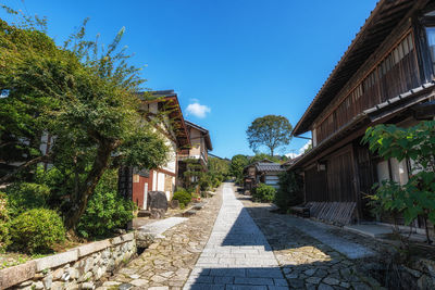 Footpath amidst buildings against clear sky