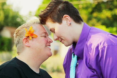 Close-up of smiling lesbian couple looking at each other while standing outdoors