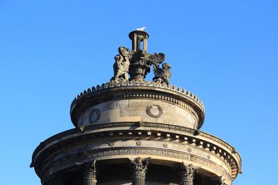 Low angle view of statue against blue sky