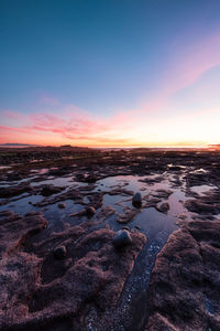 Scenic view of beach against sky during sunset