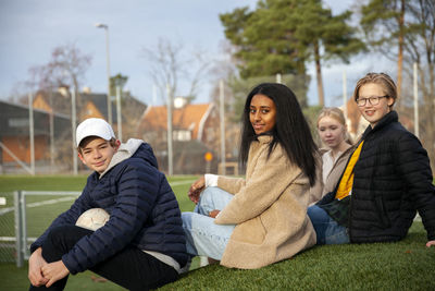 Portrait of teenage friends sitting on grass