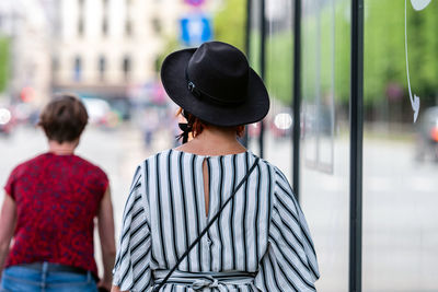 Rear view of woman with hat on street