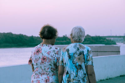 Rear view of woman standing against sky