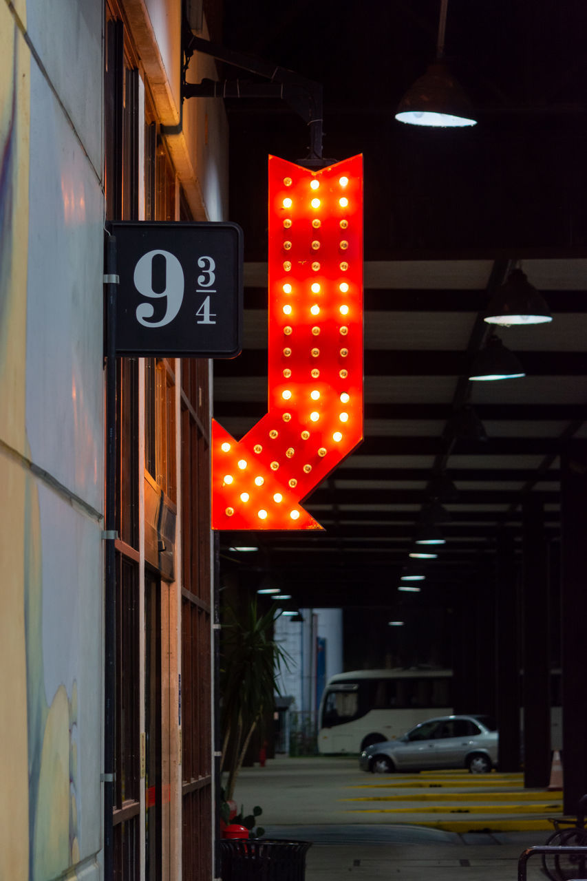 ROAD SIGN ON ILLUMINATED STREET