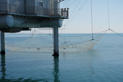 Sailboats moored in sea against sky