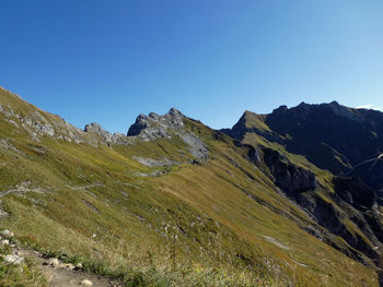 Scenic view of mountains against clear blue sky