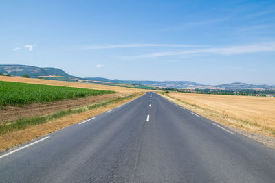 Empty road along countryside landscape