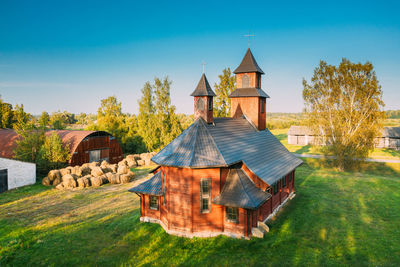 Traditional building on field against sky