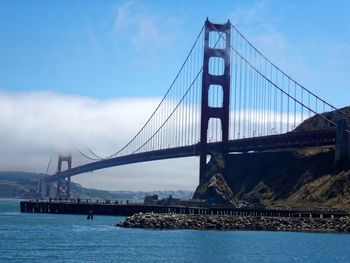 View of suspension bridge against cloudy sky