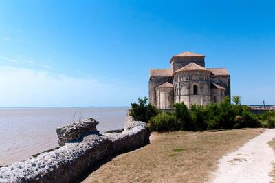 View of built structure by sea