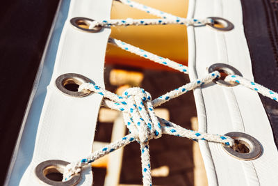 Close-up of rope tied on metal against wall