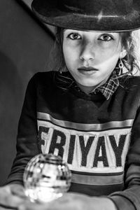 Portrait of thoughtful cute girl wearing hat while sitting at home