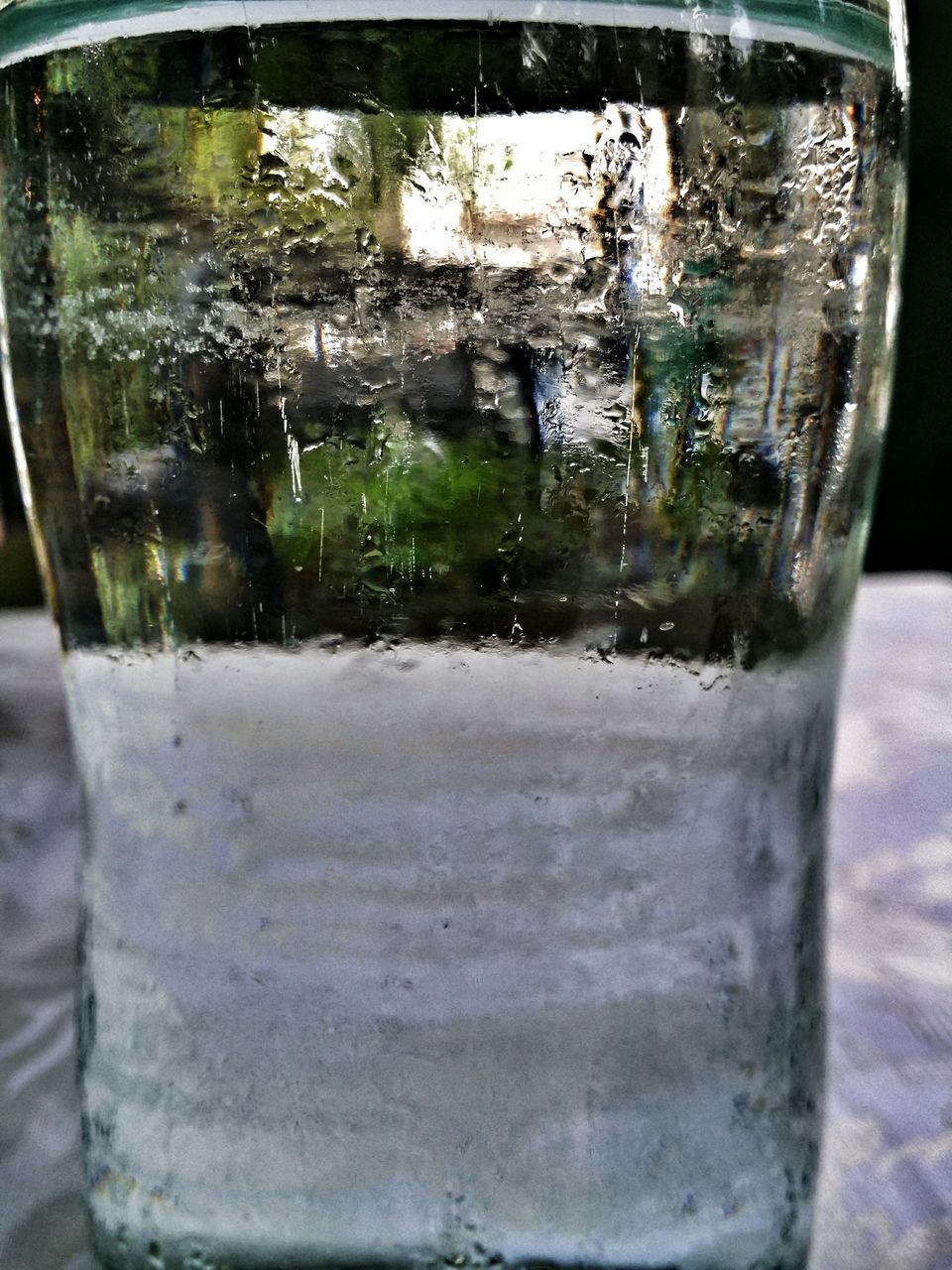 glass - material, transparent, drinking glass, drink, refreshment, indoors, freshness, glass, close-up, food and drink, water, cold temperature, window, ice, table, drop, condensation, reflection, focus on foreground, alcohol