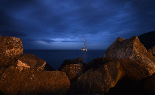 Rock formations by sea against blue sky