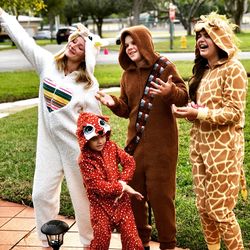 Family wearing costumes standing on footpath in park