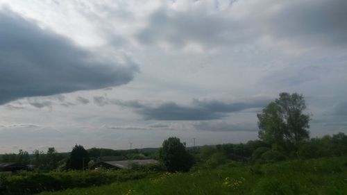 Scenic view of grassy field against cloudy sky