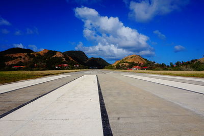 Road by mountain against sky