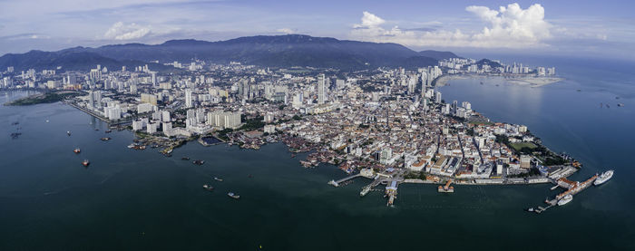 High angle view of city by sea against sky