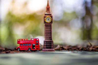Close-up of red toy tower against buildings in city